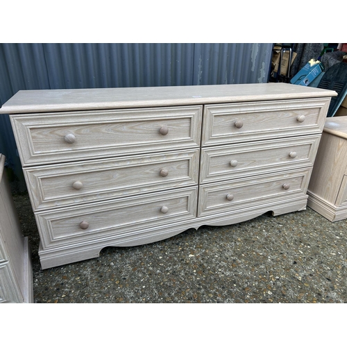 182 - A modern light oak effect lowboy chest of six drawers together with a pair of matching bedsides larg... 