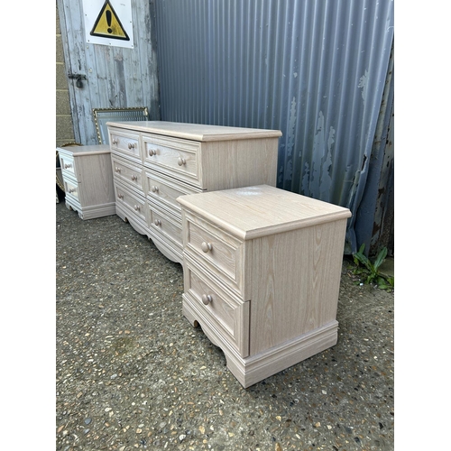 182 - A modern light oak effect lowboy chest of six drawers together with a pair of matching bedsides larg... 