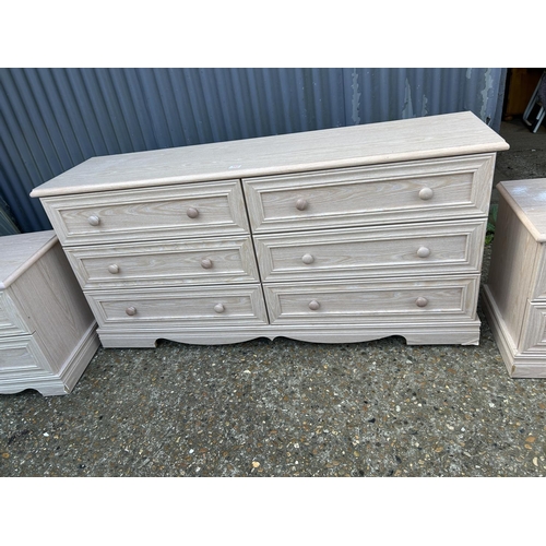 182 - A modern light oak effect lowboy chest of six drawers together with a pair of matching bedsides larg... 