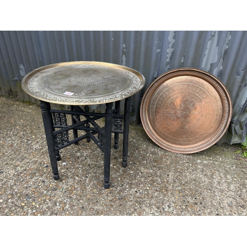 203 - A brass tray top table on folding base together with an additional copper tray