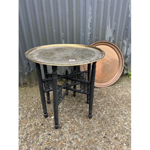 203 - A brass tray top table on folding base together with an additional copper tray