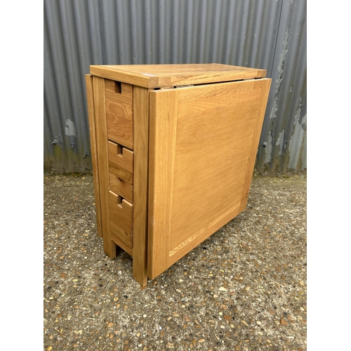 208 - A modern light oak drop leaf kitchen table with three drawers to each end