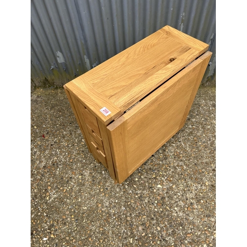 208 - A modern light oak drop leaf kitchen table with three drawers to each end