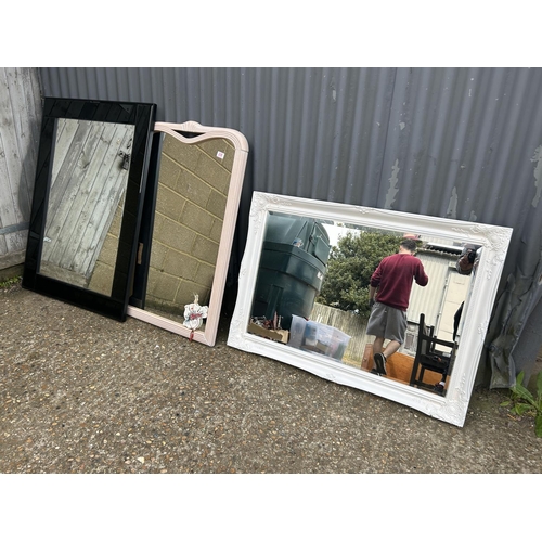 228 - A large gloss black wall mirror together with two white painted wall mirrors