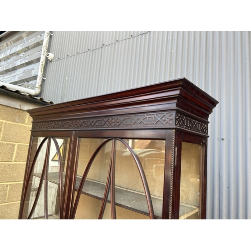 61 - A Victorian mahogany glazed two door cabinet with carved fretwork decoration 134x40x200