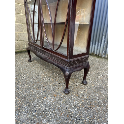 61 - A Victorian mahogany glazed two door cabinet with carved fretwork decoration 134x40x200