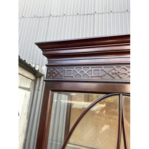 61 - A Victorian mahogany glazed two door cabinet with carved fretwork decoration 134x40x200