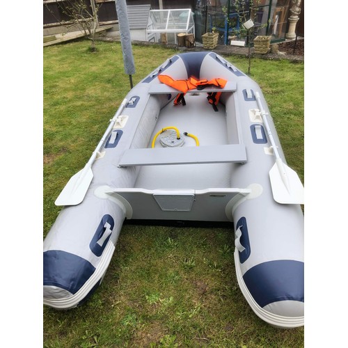 A grey inflatable dinghy boat with carry case