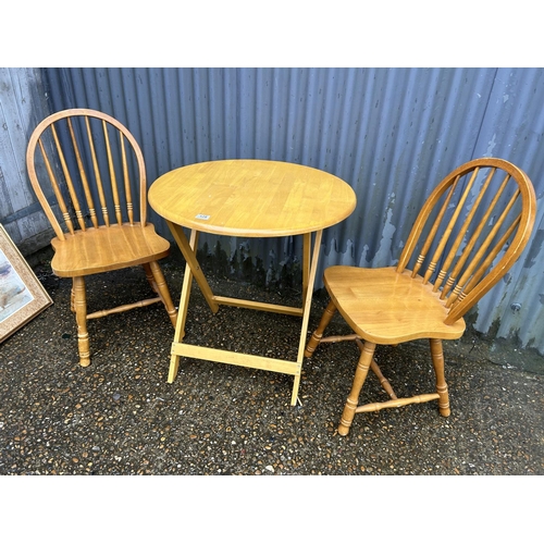 129 - A Pine folding table and two chairs