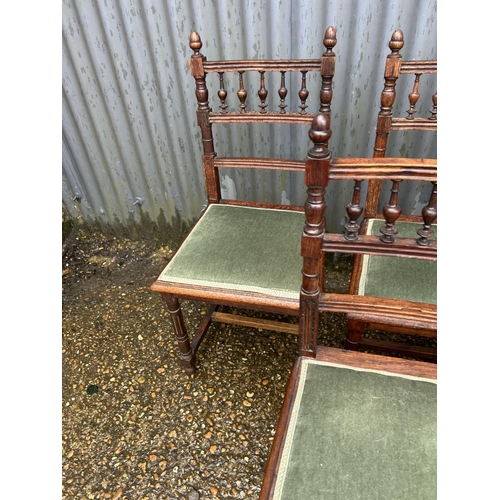 136 - A set of six oak dining chairs with green upholstered seats