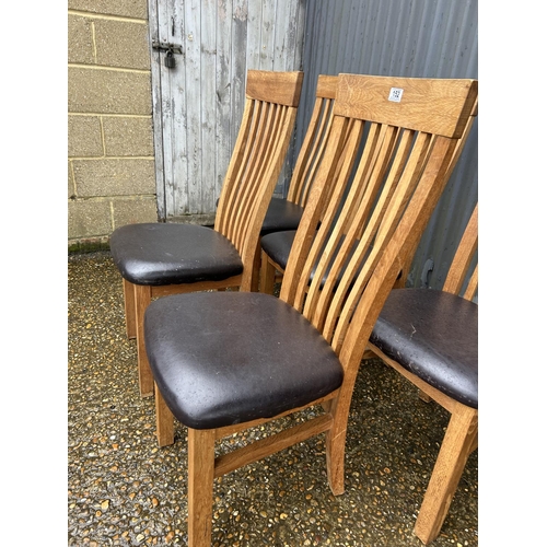 152 - A set of six modern light oak chairs with high chairs and brown faux leather seats