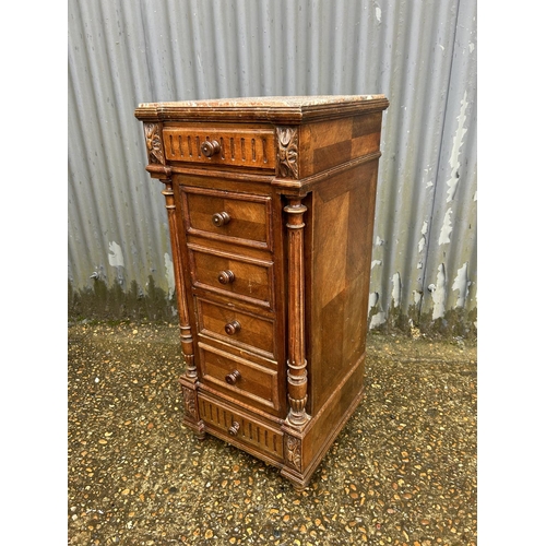 153 - A French oak marble top bedside chest of six drawers