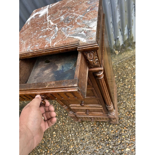 153 - A French oak marble top bedside chest of six drawers