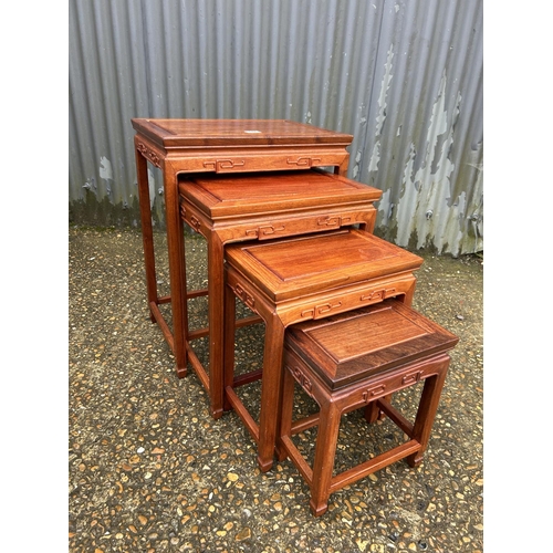 174 - AN oriental hardwood nest of four tables