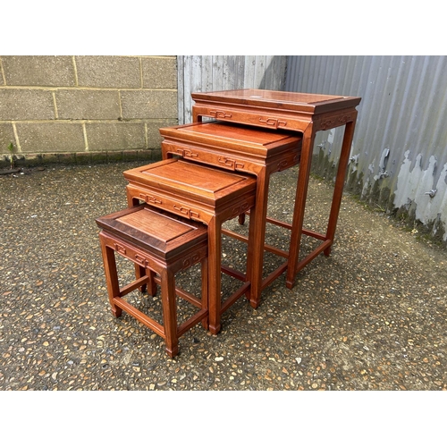 174 - AN oriental hardwood nest of four tables