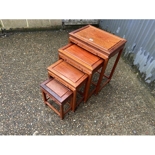 174 - AN oriental hardwood nest of four tables