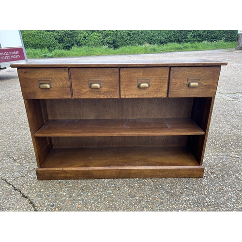 183 - A modern oak hall bookcase with four drawers 130x35x85