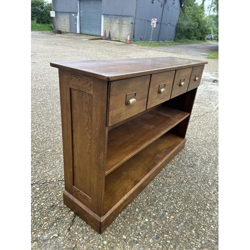 183 - A modern oak hall bookcase with four drawers 130x35x85