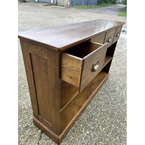 183 - A modern oak hall bookcase with four drawers 130x35x85