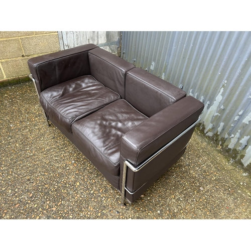 188 - A chrome framed designer sofa in the style of Le corbussier LC2 125x66x86