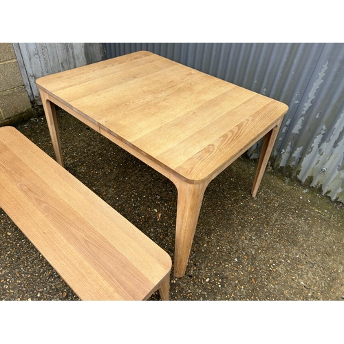 195 - A modern light oak extending dining  table from John Lewis together with matching bench 120x90x75