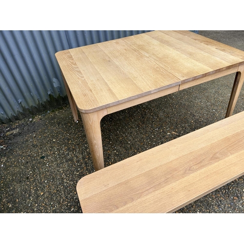 195 - A modern light oak extending dining  table from John Lewis together with matching bench 120x90x75