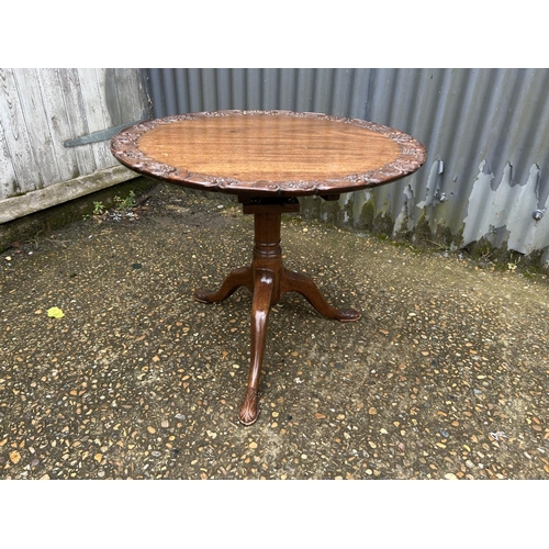 212 - An ornate carved mahogany occasional  table 66 diameter x 50 high