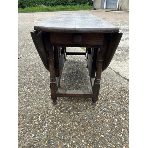 222 - A large antique oak gateleg table with drawer