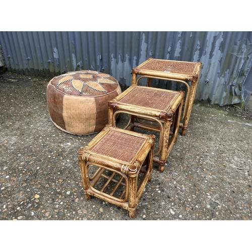 233 - A retro bamboo nest of three tables together with a leather footstool