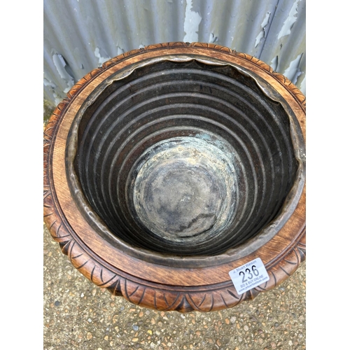 236 - A carved mahogany plant stand with brass liner