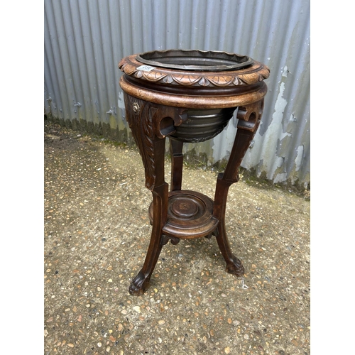 236 - A carved mahogany plant stand with brass liner