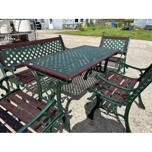 334 - A green painted iron framed garden table together with bench and three chairs