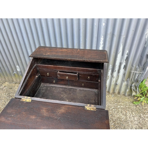 34 - An antique carved oak bureau desk with fitted interior and well 60x50x100