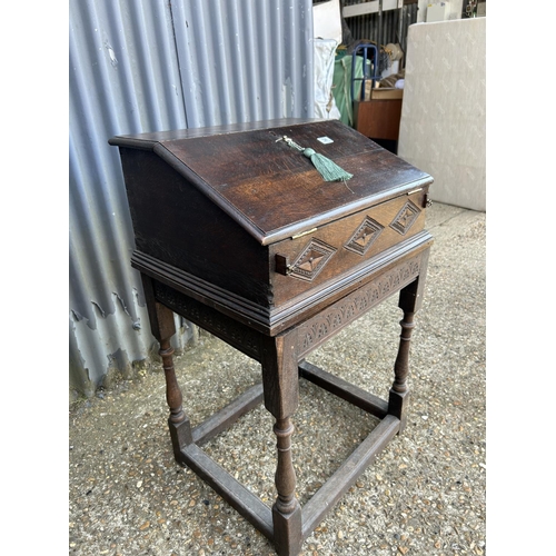 34 - An antique carved oak bureau desk with fitted interior and well 60x50x100