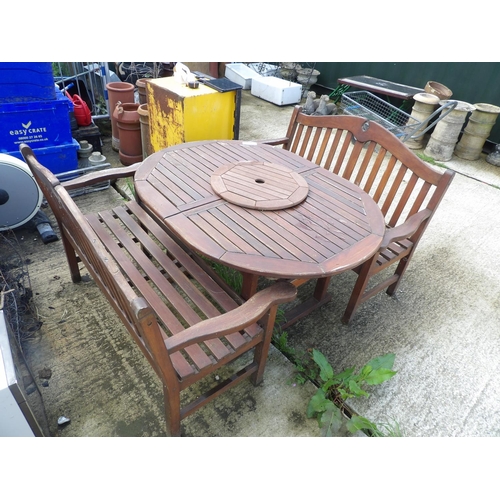 371 - An extending wooden garden table with two benches and lazy Susan