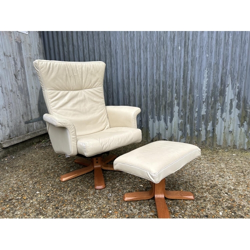 63 - A modern cream leather easy chair with matching stool