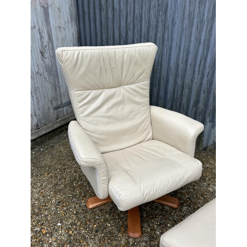 63 - A modern cream leather easy chair with matching stool