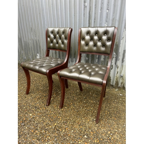 95 - A pair of green leather chesterfield chairs