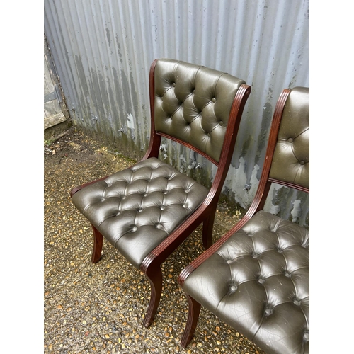 95 - A pair of green leather chesterfield chairs