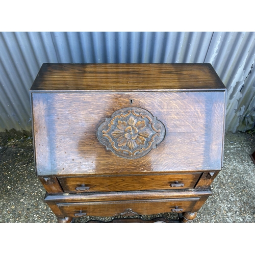 10 - A carved oak bureau 73cm wide