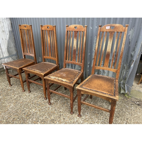 100 - A set of four arts and crafts style oak dining chairs