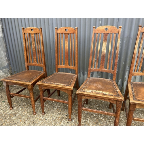 100 - A set of four arts and crafts style oak dining chairs