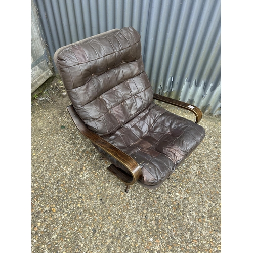 107 - A mid century brown leather easy chair