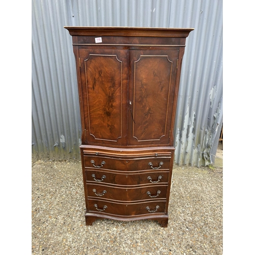 119 - A reproduction mahogany two section drinks cabinet with glazed interior