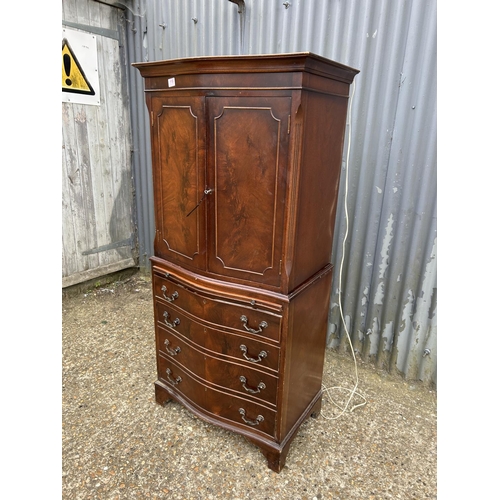 119 - A reproduction mahogany two section drinks cabinet with glazed interior