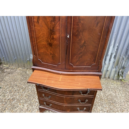 119 - A reproduction mahogany two section drinks cabinet with glazed interior