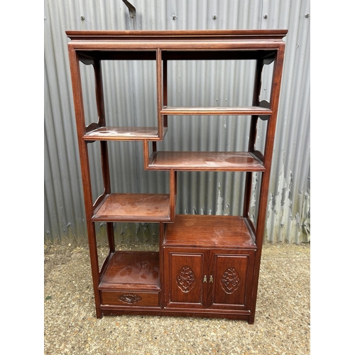 137 - An Oriental hardwood  double sided bookcase with cupboards and drawer to each side 100x40 x168