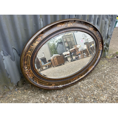 142 - An oriental lacquered oval mirror 87x60