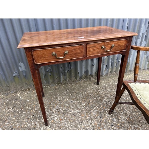 145 - A Victorian mahogany two drawer writing table together with a mahogany carver chair  80x45x77