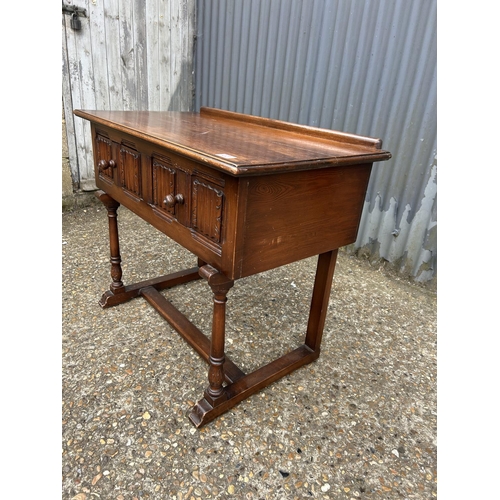 221 - An oak linenfold two drawer table 90x50 x74